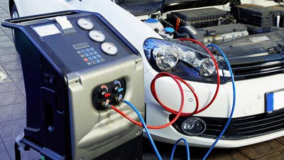 Ein PKW mit offner Motorhaube ist an ein Messgerät angeschlossen. Dieses misst die Motor- und Abgaswerte des Fahrzeugs.
