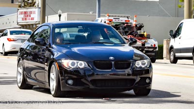 Ein Auto - ein dunkler BMW - fährt ohne vorderes Kennzeichenschild. Die Nummer fehlt.