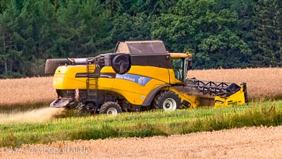 Ein großer Mähdrescher bei der Ernte auf einem Feld.