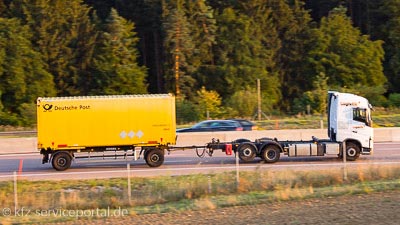 Ein Lastkraftwagen mit Anhänger fährt auf einer Autobahn.