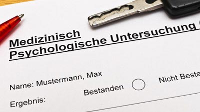 Unterlagen für eine Medizinisch psychologische Untersuchung mit Stift und Autoschlüssel