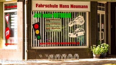 Ein Schaufenster einer Fahrschule. Auf der Scheibe sind verschiedene Aufkleber.