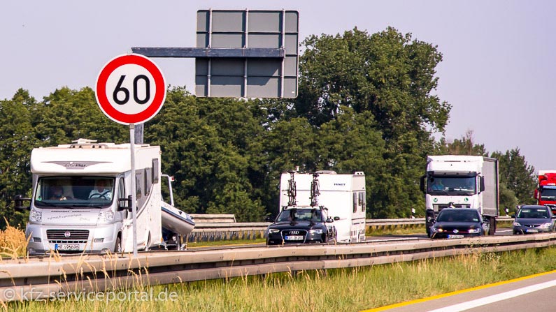 Ein Wohnmobil und ein PKW mit Wohnanhänger auf einer Autobahn.