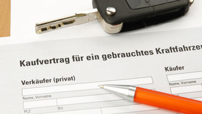 Ein Auto Kaufvertrag, ein Autoschlüssel und ein Kugelschreiber
