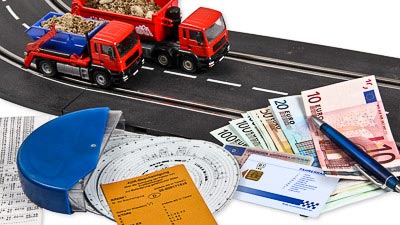 Fahrerkarte, Kontrollausdrucke der Fahr- und Lenkzeiten und zwei Modell-Lastkraftwagen.