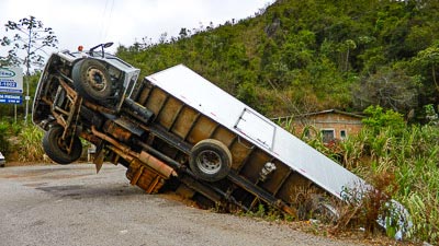 Ein verunglückter Lastkraftwagen hängt in einer Böschung.