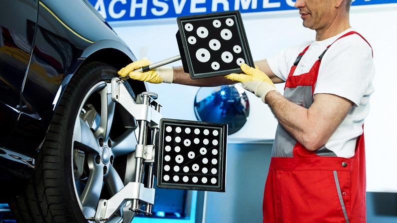 Ein Mechaniker bereitet ein Fahrzeug für die Spureinstellung vor