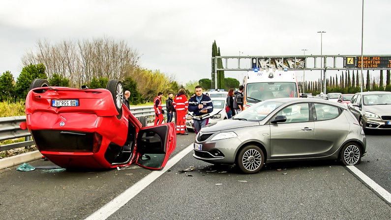 Ein Unfall mit zwei Fahrzeugen auf einer Autobahn. Ein PKW liegt auf dem Dach.