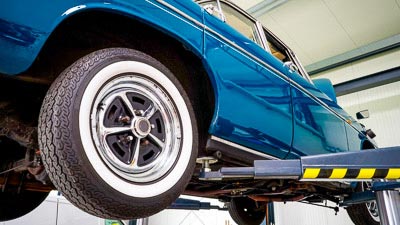 Ein blaues Auto auf einer Hebebühne in einer Kfz-Werkstatt