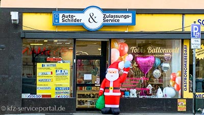 Die Geschäftsfassade  eines Zulassungsdienstes mit Werbung im Schaufenster.