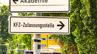 Ein Straßenschild mit der Aufschrift KFZ-Zulassungsstelle und einem Pfeil nach rechts.