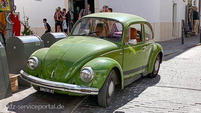 Ein alter VW Käfer mit einem ausländischen Oldtimer-Kennzeichen.