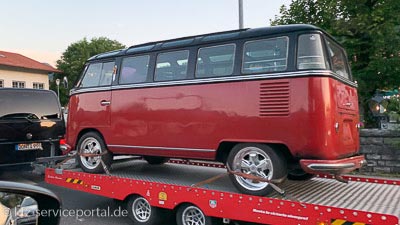 Ein VW-Bulli Oldtinmer steht auf einem Fahrzeuganhänger und wird zu einer Kfz-Prüfstelle gefahren.