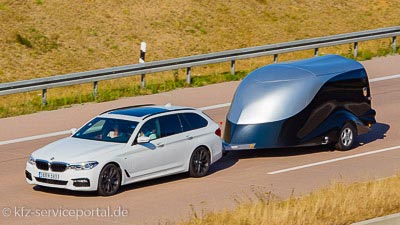 Ein windschnittiger Anhänger wird von einem Auto gezogen.
