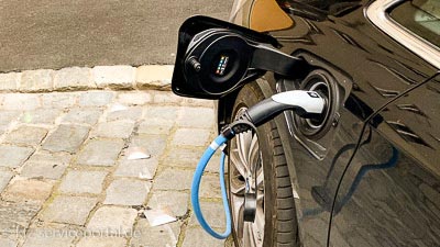 Ein Ladekabel steckt in der Steckdose eines E-Autos.