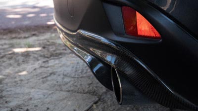 Die Heckansicht eines getunten Fahrzeuges. Man sieht die Verkleidung und den Sportauspuff.