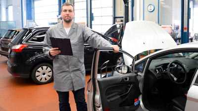 Kfz-Werkstatt mit Mitarbeiter und Kundenfahrzeug