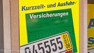 Eine Werbetafel eines Schilderladens mit Werbung für die Kurzzeitkennzeichen-Versicherung.