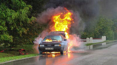 Ein brennendes Auto am Straßenrand. Dieser Schaden ist mit der Kurzzeitkennzeichen Versicherung nicht gedeckt, da darin nur Haftpflichtschäden versichert sind.