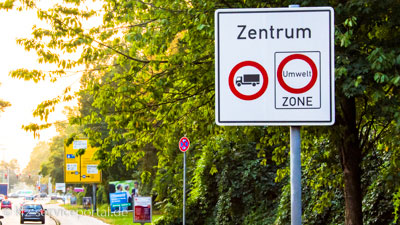 An einer Straße zeigt ein Verkehrsschild, dass das Stadtzentrum als Umweltzone ausgewiesen ist.