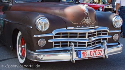 An einem Oldtimer ist ein rotes Oldtimerkennzeichen angebracht.