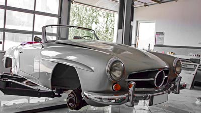 Die Karosse eines Oldtimers ist auf einer Hebebühne. Das Fahrzeug wird fachgerecht restauriert.