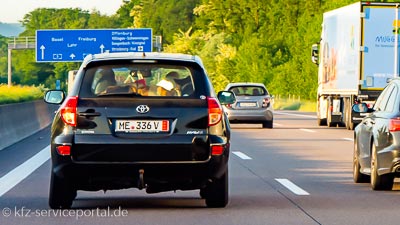 Ein Auto auf der Autobahn fährt mit einem Ausfuhrkennzeichen in Richtung Landesgrenze.