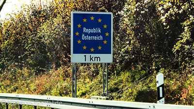 Ein Verkehrsschild zeigt in einem Kilometer die Ländergrenze zu Österreich an.