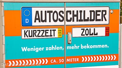 Auf einer Werbeschild ist ein Hinweis auf einen Schilderladen, bei welchem Kurzzeitkennzeichen Schilder angefertigt werden.