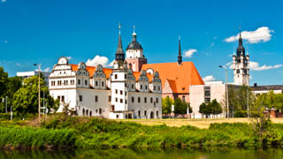 Im Vordergrunde steht das Residenzschloss, auch Stadtschloss genannt. Im Hintergrund ist die Marienkirche und der Rathaustrum an der Mulde Dessau zu sehen.