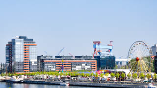 Kieler Woche an der Hafenpromenade, Kieler Förde mit einem Kreuzfahrtschiff im Hintergrund und dem Hochhauscenter am Germaniahafen