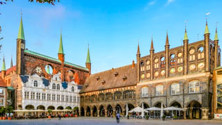 Das im Winkel stehende Lübecker Rathaus und das Kanzleigebäude in der Fußgängerzone