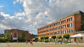 Das neue Nordenstedter Rathaus mit einem großen Platz und Bäumen eingefasst